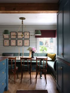 a dining room with blue cabinets and wooden table in the center, surrounded by chairs