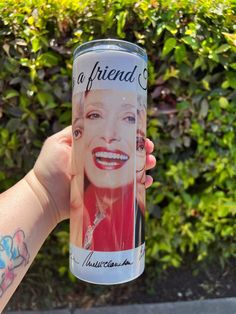 a person holding up a can of soda with a picture of marilyn monroe on it