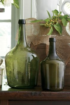 two green vases sitting on top of a wooden table