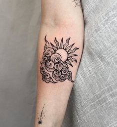 a sun and clouds tattoo on the arm