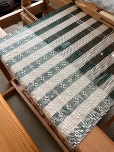 a close up of a weaving machine with yarn on the table and in the background