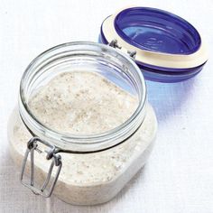 a glass jar filled with food sitting on top of a table next to a blue bowl