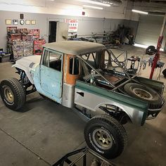 an old pick up truck is parked in a garage with lots of work on it