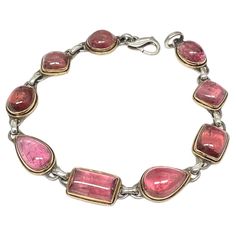 Nine variable shaped approximately 7 x 10 to 9 x 12 mm Mozambique pink tourmaline cabochons are set in 18K gold bezels with surrounding 18K gold wire accents atop sterling silver bases and links in this organic Steven Battelle design. 7.5 inch length fits medium to larger wrists. One stone could be removed to fit a small wrist. By using the silver as a base, it reduces the cost significantly. A really great price for a beautiful pink tourmaline bracelet ! Modern Bracelets, Tourmaline Bracelet, Tourmaline Beads, Gold Wire, Pink Tourmaline, Mozambique, Tourmaline, Silver Bracelet, 18k Gold