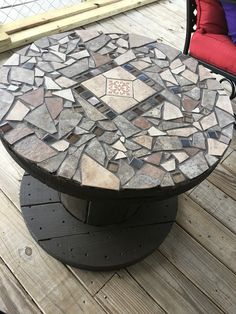 an outdoor table made out of stones on a deck