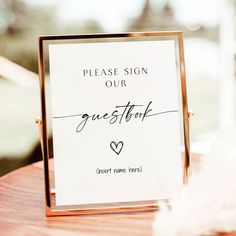 a close up of a sign on a table with a feather in the foreground