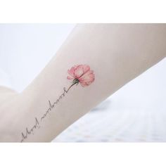 a woman's arm with a pink flower on it