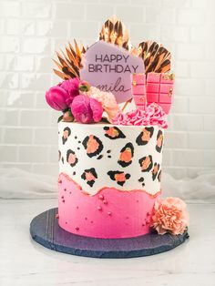 a birthday cake decorated with leopard print and pink flowers