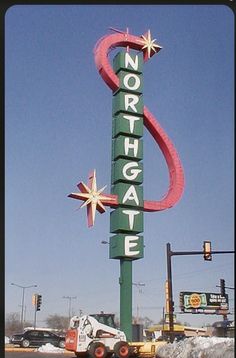 a large neon sign that says northgate on the side of a road with cars parked in front of it