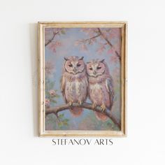 two owls sitting on a branch with pink flowers