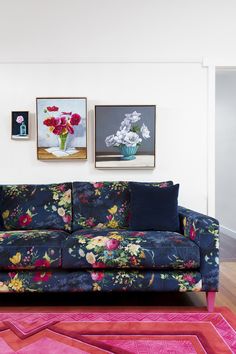 a living room filled with furniture and pictures on the wall above it's colorful rug