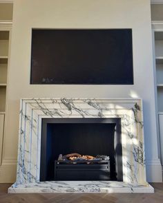 a fireplace with white marble surround and black mantle