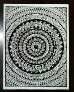 a black and white drawing on paper with an intricate design in the center, surrounded by smaller circles