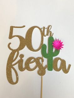 a cake topper that says 50 off fiesta with a pink flower in the middle