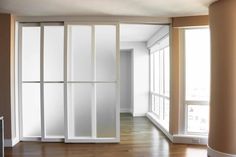 an empty room with sliding glass doors and hard wood flooring on the side wall