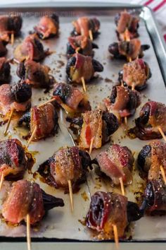 meat and olives on skewers with toothpicks ready to be cooked