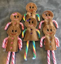 several gingerbread man made out of felt with candy canes in the middle and on top