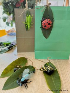 some bugs are sitting on top of green leaves and hanging from the handles of shopping bags