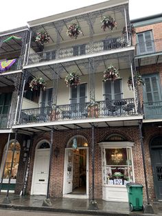 an old building with many balconies on the second floor and flowers hanging from the balcony