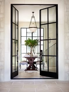 an open door leading to a dining room with a potted plant on the table