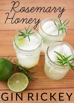 three mason jars filled with lemonade and rosemary garnish next to limes