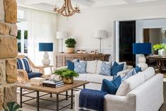 a living room filled with furniture and a chandelier hanging over the top of it