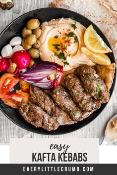 kebabs on a plate with vegetables and pita bread