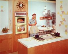 a woman standing next to an oven in a kitchen