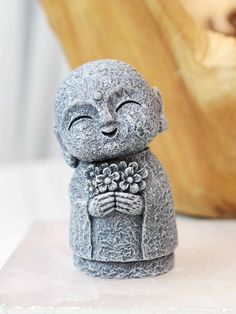 a small buddha statue sitting on top of a white counter