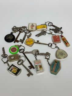 an assortment of keychains are shown on a white surface