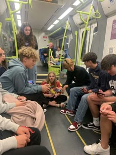 a group of young people sitting on a subway train