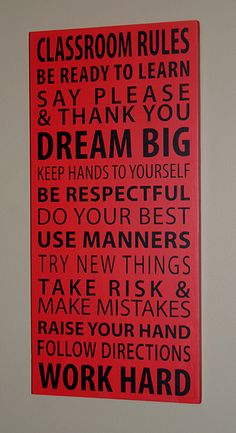 a red poster with words written in black on the front and bottom, which reads classroom rules be ready to learn