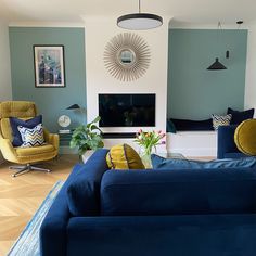 a living room filled with furniture and a flat screen tv mounted on a wall above a fireplace