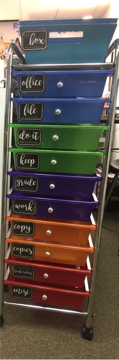 a stack of colorful drawers sitting on top of a metal rack