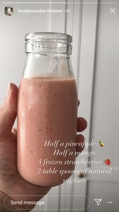 a person holding a glass jar filled with pink smoothie and information about the ingredients