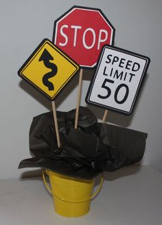 there are two signs that say stop and speed limit on sticks in front of a trash bag