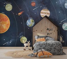 a child's bedroom with planets and stars on the wall, including a bed