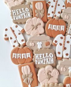 decorated cookies are arranged in the shape of pumpkins and teddy bears with words hello pumpkin on them