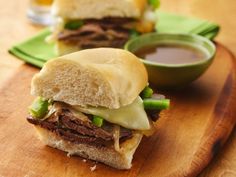 two sandwiches sitting on top of a wooden cutting board