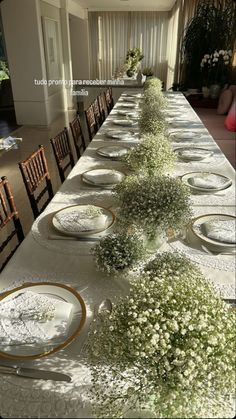 a long table with plates and flowers on it