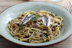 a bowl filled with pasta and topped with fish