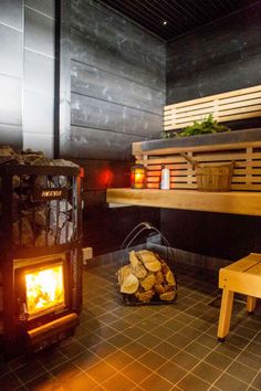 a wood burning stove sitting next to a wooden bench