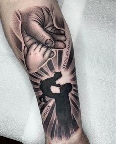 a man's arm with a black and white tattoo on it, holding the hand of another person