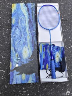 a tennis racquet sitting in a box on the ground next to it's contents