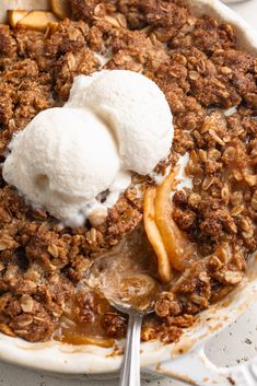 an apple crisp with ice cream on top in a pie dish, ready to be eaten