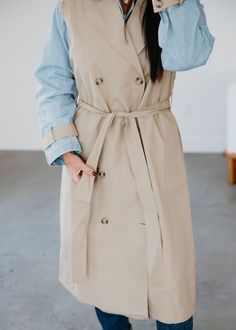 Layered look trench coat with denim jacket lining. Laurie is wearing a size small. Measurements: Body Length: 47" | Sleeve Length: 22" Small: Bust: 44" Waist: 42" Arm: 19" Medium: Bust: 45" Waist: 44" Arm: 19" Large: Bust: 46" Waist: 47" Arm: 20" Self: 66% Rayon 34% Polyester Contrast: 100% Rayon Classic Spring Outerwear For Layering, Classic Spring Layering Outerwear, Spring Collared Belted Outerwear, Spring Workwear Outerwear In Gabardine, Spring Belted Button-up Outerwear, Spring Workwear Outerwear: Long Coat, Spring Long Coat For Workwear, Spring Workwear Long Coat, Spring Utility Outerwear In Gabardine