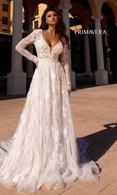 a woman in a white wedding dress posing for the camera with her hands on her hips