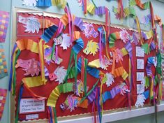 a bulletin board decorated with colorful paper streamers and ribbons hanging from it's sides