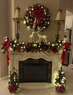 a fireplace decorated for christmas with lights and wreaths on the mantel above it