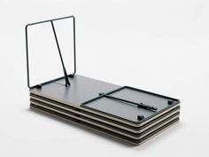 a stack of four black trays sitting on top of each other in front of a white background